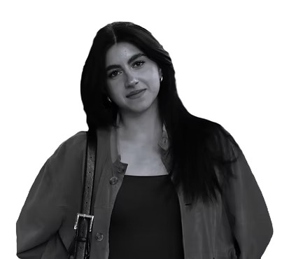 Giovane donna con capelli lunghi e scuri, indossa una giacca e tiene una borsa a tracolla. Sfondo bianco.