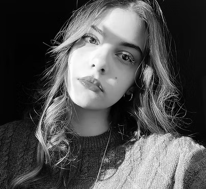 Ritratto in bianco e nero di una giovane donna con capelli mossi e sguardo intenso, indossa un maglione.