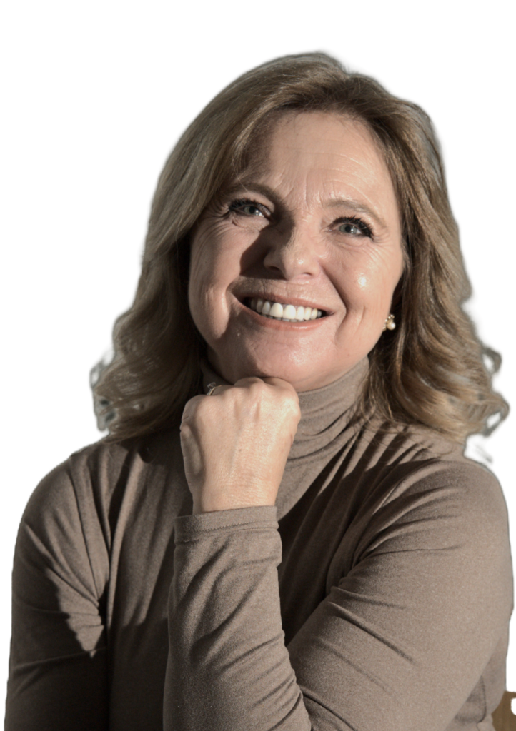 Donna sorridente con capelli biondi e maglione beige, appoggiata con il mento sulla mano.